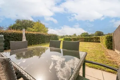 a glass table and chairs on a patio at Cosy 4BR Cottage in Great Glemham Village in Great Glemham