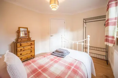 a bedroom with a bed and a dresser and a mirror at Cosy 4BR Cottage in Great Glemham Village in Great Glemham
