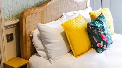 a pile of pillows sitting on top of a bed at The White Hart Inn in Margaretting