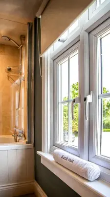 a window in a bathroom with a sink and a bath tub at The White Hart Inn in Margaretting