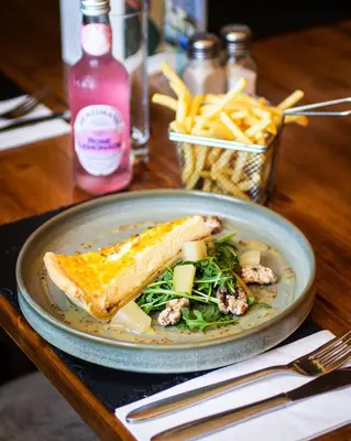 a plate of food with a sandwich and french fries at The White Hart Inn in Margaretting