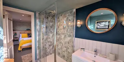 a bathroom with a shower and a sink and a mirror at The White Hart Inn in Margaretting