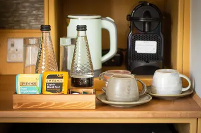 a kitchen counter with a coffee maker and some cups at The White Hart Inn in Margaretting