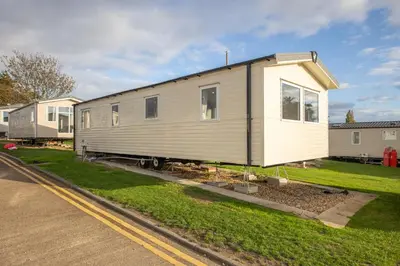 a tiny house sitting on the side of a road at New - 3 bedroom Caravan, 140 Pasture Lane in Great Clacton