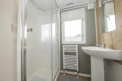 a bathroom with a glass shower and a sink at New - 3 bedroom Caravan, 140 Pasture Lane in Great Clacton