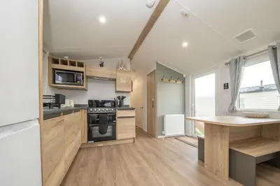 a kitchen with wooden cabinets and a counter top at New - 3 bedroom Caravan, 140 Pasture Lane in Great Clacton