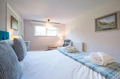 a bedroom with a large white bed and a window at 5 Church Close (7 guests), Aldeburgh in Aldeburgh