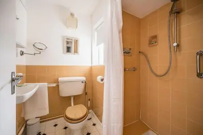 a bathroom with a toilet and a sink and a shower at 5 Church Close (7 guests), Aldeburgh in Aldeburgh