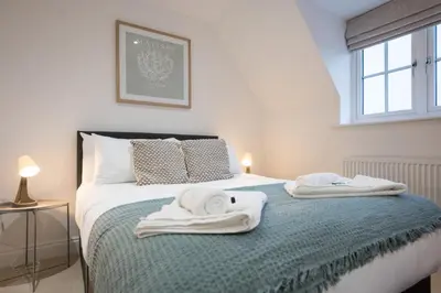 a bedroom with a bed with towels on it at Stylish 2BR in Wickham Market in Wickham Market