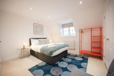 a bedroom with a bed and a blue rug at Stylish 2BR in Wickham Market in Wickham Market