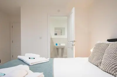 a white bedroom with a bed and a sink at Stylish 2BR in Wickham Market in Wickham Market