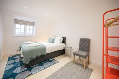 a bedroom with a bed and a chair at Stylish 2BR in Wickham Market in Wickham Market