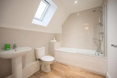 a bathroom with a toilet and a sink and a bath tub at Stylish 2BR in Wickham Market in Wickham Market