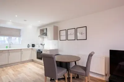 a kitchen with a table and chairs in a room at Stylish 2BR in Wickham Market in Wickham Market