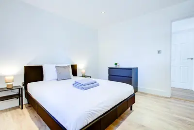 a bedroom with a large white bed with two lamps at Modern 4 Bed Home with Driveway in Colchester