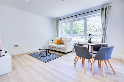 a living room with a table and a couch at Modern 4 Bed Home with Driveway in Colchester