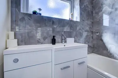 a white bathroom with a sink and a tub at Modern 4 Bed Home with Driveway in Colchester
