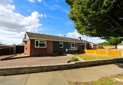 a red brick house with a tree in front of it at Modern 4 Bed Home with Driveway in Colchester