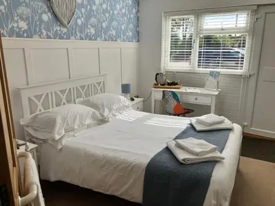 a bedroom with a bed with white sheets and a window at White hart public house in Ashill