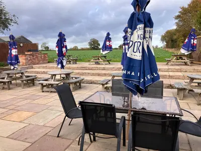 a table and chairs with umbrellas on top of it at White hart public house in Ashill