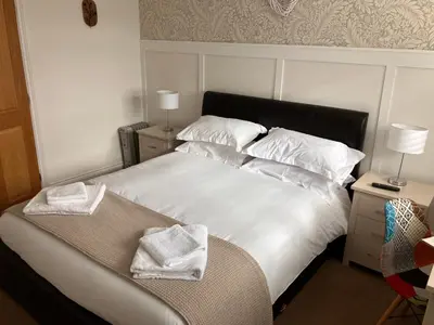 a bedroom with a white bed with towels on it at White hart public house in Ashill