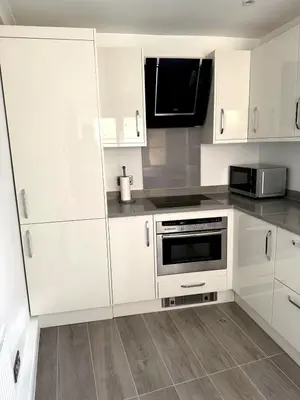 a kitchen with white cabinets and a microwave at Cosy Central Colchester Home by Castle Park in Colchester