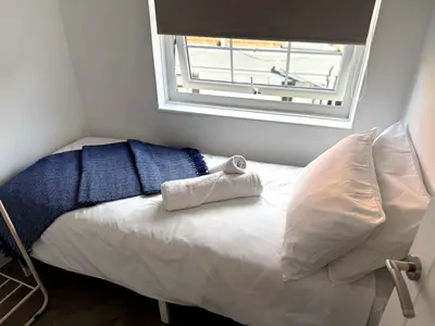 a small bedroom with a bed with a window at Cosy Central Colchester Home by Castle Park in Colchester