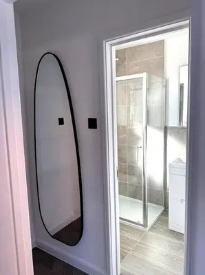 a mirror on a wall next to a bathroom at Cosy Central Colchester Home by Castle Park in Colchester