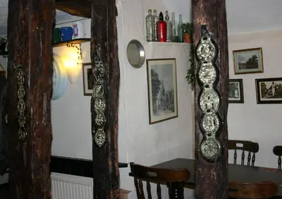 a dining room with a table and a mirror at Farmhouse Inn in Thaxted