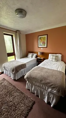 a bedroom with two beds and a window at Farmhouse Inn in Thaxted