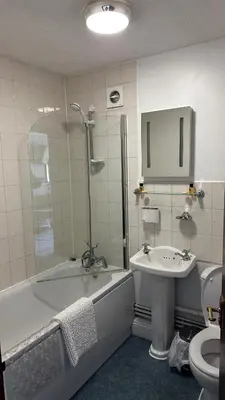a bathroom with a sink and a tub and a toilet at Farmhouse Inn in Thaxted