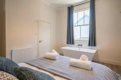 a bedroom with a bed and a tub and a window at Fabulous 1 bed in Aldeburgh in Aldeburgh