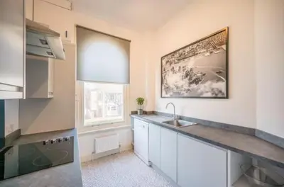 a kitchen with white cabinets and a sink and a window at Fabulous 1 bed in Aldeburgh in Aldeburgh