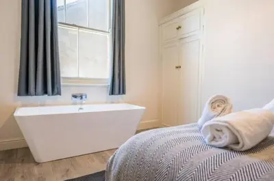 a bathroom with a bed and a tub and a window at Fabulous 1 bed in Aldeburgh in Aldeburgh