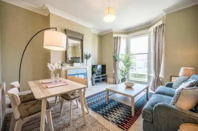 a living room with a blue couch and a table at Fabulous 1 bed in Aldeburgh in Aldeburgh