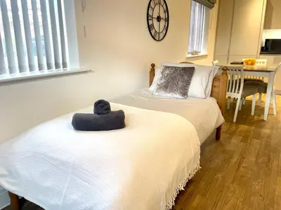 a bedroom with two beds with a hat on the bed at Modern cosy 2 bed, free parking Bishops Stortford in Bishops Stortford