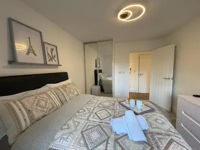 a bedroom with a bed with two towels on it at Modern cosy 2 bed, free parking Bishops Stortford in Bishops Stortford
