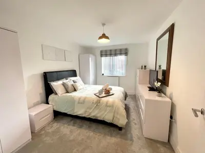 a small bedroom with a bed and a mirror at Modern cosy 2 bed, free parking Bishops Stortford in Bishops Stortford