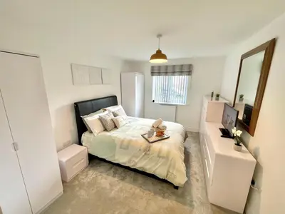 a small bedroom with a bed and a mirror at Modern cosy 2 bed, free parking Bishops Stortford in Bishops Stortford