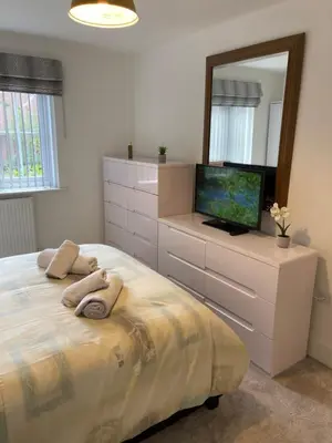a bedroom with a bed with a tv and a mirror at Modern cosy 2 bed, free parking Bishops Stortford in Bishops Stortford