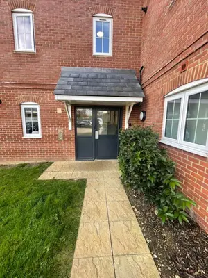 a brick house with a black door and a sidewalk at Modern cosy 2 bed, free parking Bishops Stortford in Bishops Stortford