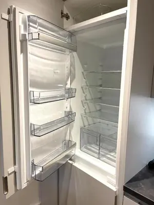 a refrigerator with its door open with its empty shelves at Modern cosy 2 bed, free parking Bishops Stortford in Bishops Stortford