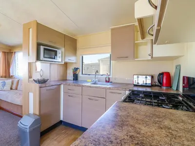 a kitchen with a sink and a stove top oven at Singh Leite & Luisa Family Caravan in Clacton-on-Sea