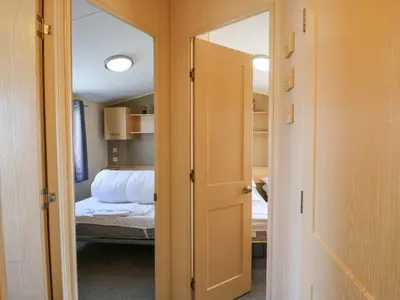 a door leading to a bedroom with a bed at Singh Leite & Luisa Family Caravan in Clacton-on-Sea