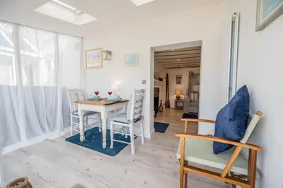 a dining room with a table and chairs at 2 Beach Cottages, Thorpeness in Thorpeness
