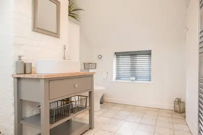 a bathroom with a sink and a toilet at 2 Beach Cottages, Thorpeness in Thorpeness