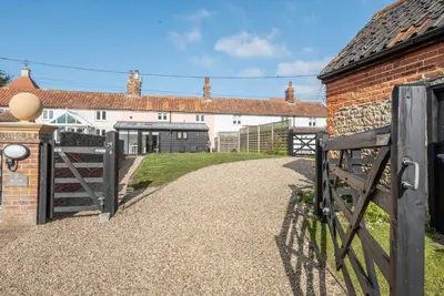 a gate to a house with a brick building at 2 Beach Cottages, Thorpeness in Thorpeness
