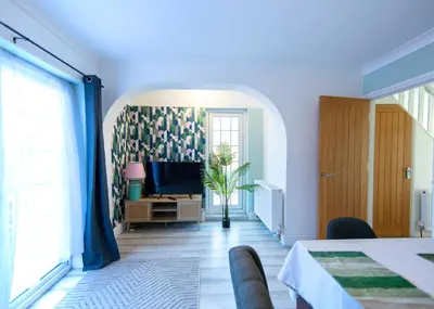 a living room with a tv and a table at Bright & Airy 4x Bed House with Parking in Ely