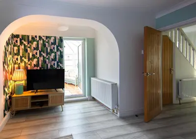 a living room with a flat screen tv on a table at Bright & Airy 4x Bed House with Parking in Ely