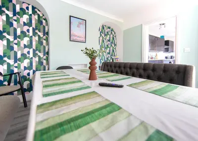 a dining room table with a remote control on it at Bright & Airy 4x Bed House with Parking in Ely